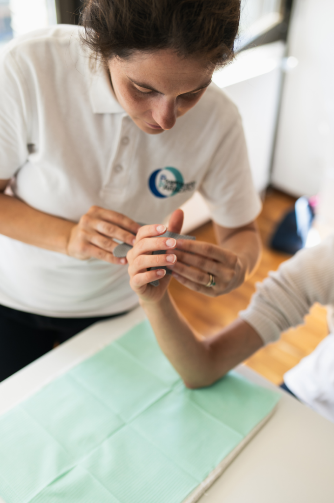 Ergoterapista che assiste un paziente nella mobilizzazione della mano.