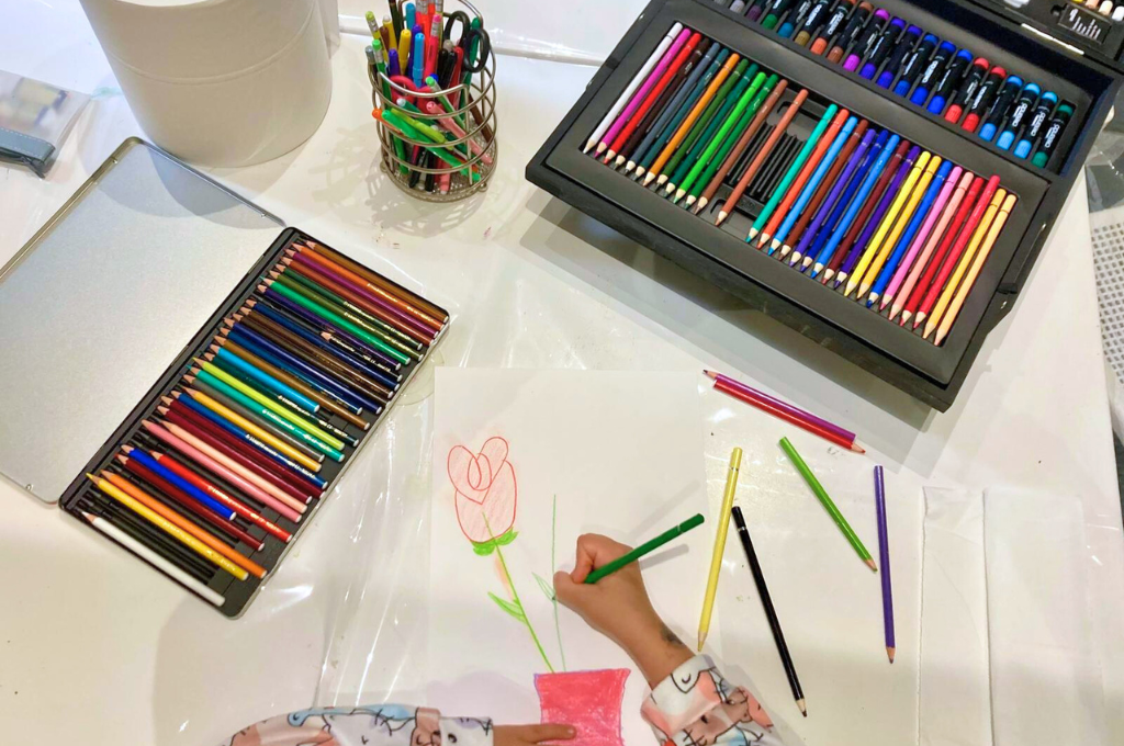 Bambino durante laboratorio creativo al Polispecialistico Paradiso: disegno con matite colorate per esprimere emozioni e creatività