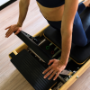 Dettaglio mani durante esercizio Pilates su Reformer