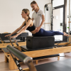Esercizio Pilates su Reformer con estensione del tronco assistita.